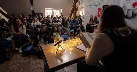 Image of students sitting together in a circle reading and listening