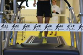 A man on a treadmill with M2S logo next to him