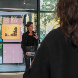 Image of Caroline Cieslik speaking in front of guests at the opening